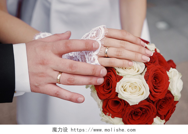 新婚夫妇举办婚礼金戒指新娘和新郎在婚礼花束的双手